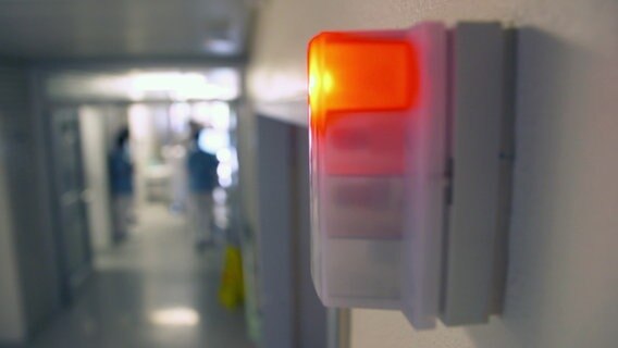 Eine Lampe neben einer Zimmertür in einem Krankenhaus leuchtet rot. © NDR 