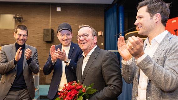 Boris Pistorius hält einen Blumenstrauß während Menschen um ihn herum klatschen. © picture alliance/dpa | Foto: Moritz Frankenberg