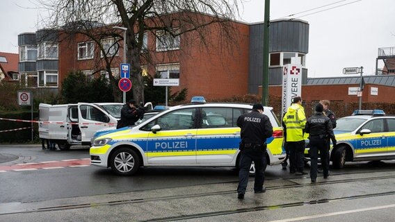 Polizeiwagen und Beamte neben einem mit Flatterband abgesperrten Transporter. © dpa Foto: Julian Stratenschulte