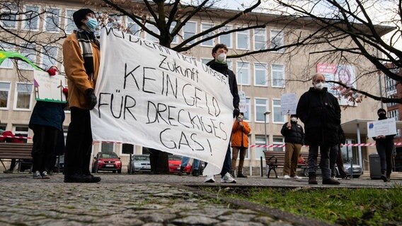 Demonstranten steht mit einem kritischen Plakat zu Fracking vor dem Landtag von Niedersachsen. © dpa/Julian Stratenschulte Foto: Julian Stratenschulte
