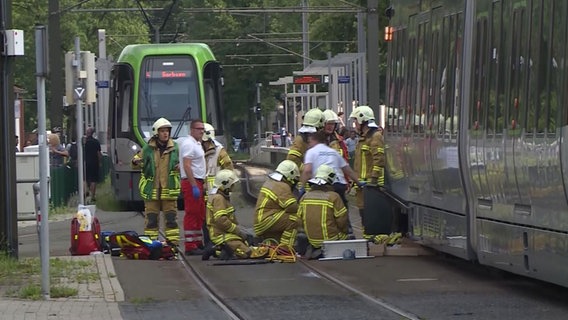 Einsatzkräfte der Feuerwehr versuchen eine Person unter einer Straßenbahn zu bergen. © TeleNewsNetwork 