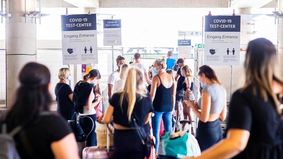 Reiserückkehrer warten in einer Schlange am Flughafen Hannover auf ihren Corona-Test. © picture-alliance 