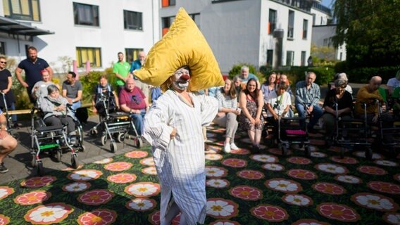Clown Anatoli Akerman vom Circus Roncalli steht bei einem Aufritt im psychiatrischen Pflegeheim der Dr. med. Anne M. Wilkening GmbH. © Julian Stratenschulte/dpa Foto: Julian Stratenschulte