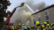 Einsatzkräfte der Feuerwehr löschen ein brennendes Gebäude an einem Sportpark in Ronnenberg. © TeleNewsNetwork 