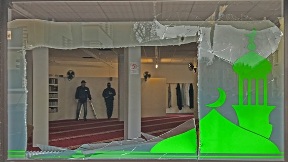 Vier Menschen stehen vor einem eingeschlagenen Fenster eines islamistischen Vereins in Hildesheim. © NDR Foto: Stefan Schölermann