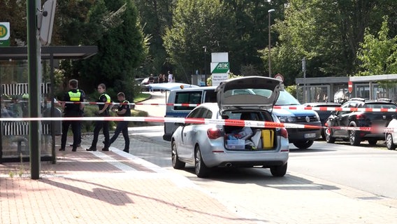 Eine Polizistin und ein weiße Schutzanzüge gekleidete Einsatzkräfte sichern Spuren am Tatort in Sarstedt. © NonstopNews Aktuell 