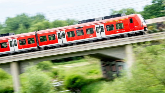 Ein Zug der S-Bahn Hannover mit Fahrtziel Nienburg (Weser) fährt über eine Brücke am Bahnhof Hannover-Linden. © dpa-Bildfunk Foto: Hauke-Christian Dittrich/dpa