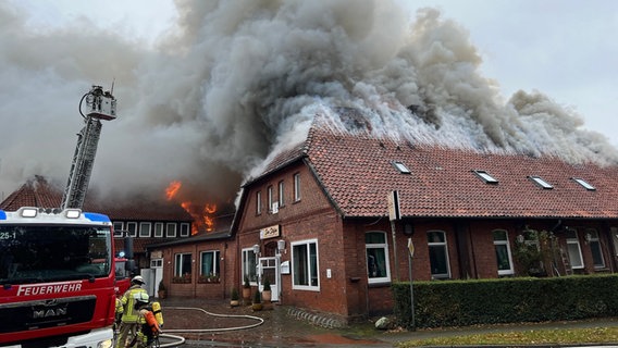 Feuerwehrleute an einem brennenden Haus, aus dem starker Rauch aufsteigt © Feuerwehr Neustadt am Rübenberge 