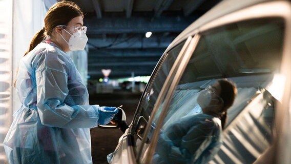 Eine Mitarbeiterin testet in einem Testzentrum in Hannover eine Person in einem Auto auf das Coronavirus. © dpa-Bildfunk Foto: Julian Stratenschulte