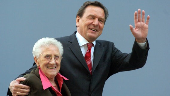 Im Jahr 2004 hält der damalige Bundeskanzler Gerhard Schröder (SPD) seine Mutter Erika Vosseler im Arm. © dpa/picture-alliance Foto: Kay Nietfeld