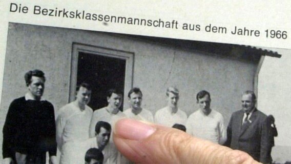 Ein Finger zeigt auf Gerhard Schröder auf einem Foto der Bezirksklassen-Fußballmannschaft  des TuS Talle aus dem Jahr 1966. © dpa/picture-alliance 