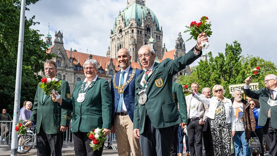 Uwe Weimann (l-r), Vizepräsident vom Niedersächsischen Sportschützenverband, Sabine Tegtmeyer-Dette (Bündnis 90/Die Grünen), Staatssekretärin im Finanzministerium Niedersachsen, Belit Onay (Bündnis 90/Die Grünen), Oberbürgermeister von Hannover, und Paul-Eric Stolle, Präsident vom Verband Hannoverscher Schützenvereine e.V., laufen beim Schützenausmarsch vor dem Neuen Rathaus durch die Innenstadt von Hannover. © dpa-Bildfunk Foto: Michael Matthey