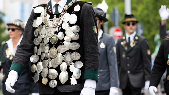 Ein Teilnehmer vom Schützenausmarsch trägt verschiedene Orden auf seiner Uniform und läuft durch die Innenstadt von Hannover. © dpa-Bildfunk Foto: Michael Matthey