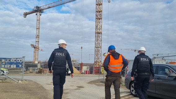 Zollbeamte gehen in Richtung Baustelle (Thema: Schwarzarbeit). © NDR Foto: Bernd Reiser