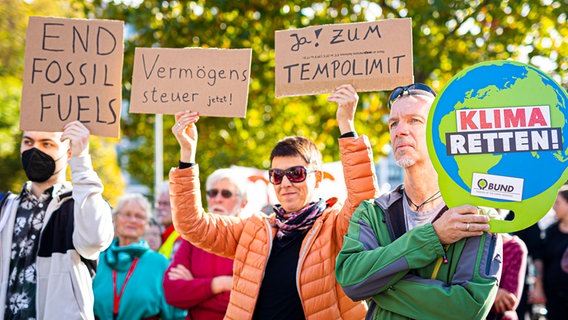 Demonstrierende halten Schilder in die Luft. © Moritz Frankenberg/dpa Foto: Moritz Frankenberg/dpa