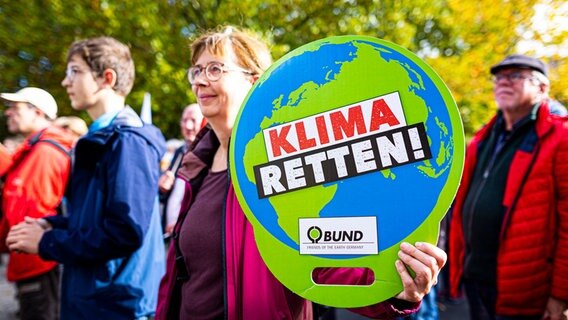 "Klima retten" steht auf dem Schild einer Demonstrierenden. © Moritz Frankenberg/dpa Foto: Moritz Frankenberg/dpa