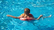 Ein Junge treibt in einem Schwimmring im Wasser. © dpa-Bildfunk Foto: Sebastian Kahnert