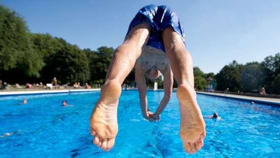 Ein Mann springt vom Beckenrand in ein Schwimmbecken. © dpa-Bildfunk Foto: Sebastian Kahnert