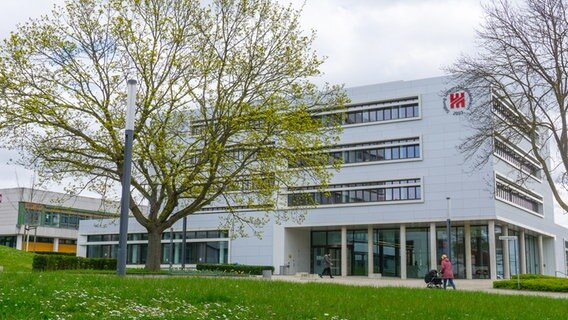 Vor einem Gebäude der Universität Hildesheim schiebt eine Frau einen Kinderwagen. © Universität Hildesheim Foto: Insa Lange