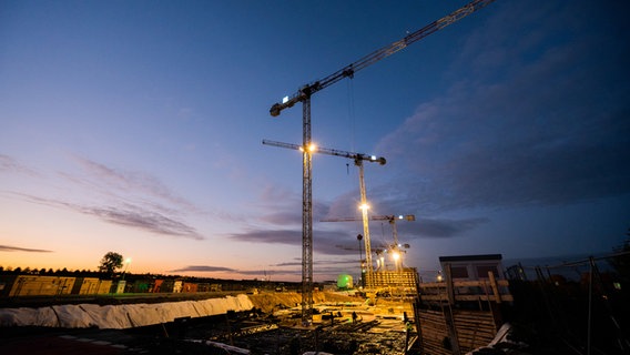 Baukräne stehen am frühen Morgen im Neubaugebiet Kronsrode. © dpa-Bildfunk Foto: Julian Stratenschulte