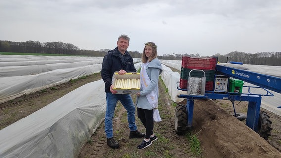 Spargelkönigin Lea Stieber und Spargelbauer Clemens Mertens präsentieren den ersten Spargel aus dem Landkreis Nienburg. © NDR Foto: Svenja Estner