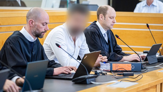Angeklagter in einem weißen Hemd zwischen zwei Anwälten  in einem Saal im Landgericht Hannover © picture alliance/dpa | Moritz Frankenberg Foto: Moritz Frankenberg