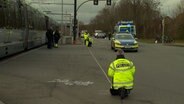 Einsatzkräfte der Polizei nehmen an einer Unfallstelle neben einer Stadtbahn Spuren auf. © HannoverReporter 