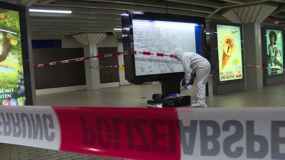 Ein in weißem Schutzanzug gekleideter Polizist sichert Spuren an der U-Bahn-Station Steintor in Hannover. © TNN/dpa 
