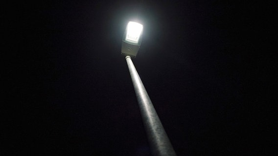 Bei Nacht ist aus der Froschperspektive eine leuchtende Straßenlaterne in Hannover zu sehen. © NDR Foto: Julius Matuschik