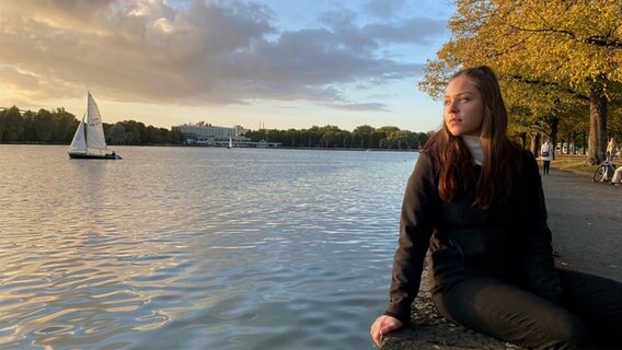 Die Studentin Vivien Dziuk sitzt bei Sonnenuntergang am Maschsee in Hannover. © NDR Foto: Tullio-Francesco Puoti