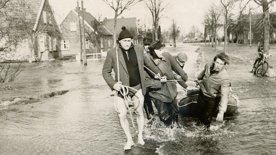 Bewohner von der Gemeinde Völlen ziehen nach der Sturmflut 1962 ein Schlauchboot durch den Ort. © Archiv Gemeinde Westoverledingen 