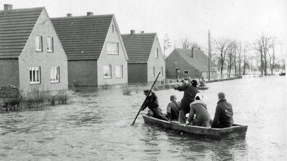 Bewohner der Gemeinde Völlen fahren nach der Sturmflut 1962 mit einem Boot durch den Ort. © Archiv Gemeinde Westoverledingen 