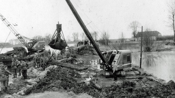 Mit Kränen arbeiten Bewohner 1962 an dem gebrochenen Deich in Papenburg. © Archiv Gemeinde Westoverledingen 