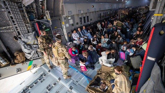 Im Laderaum eines Bundeswehr-Frachtflugzeugs sitzen afghanische Flüchtlinge. © Bundeswehr/dpa Foto: Marc Tessensohn
