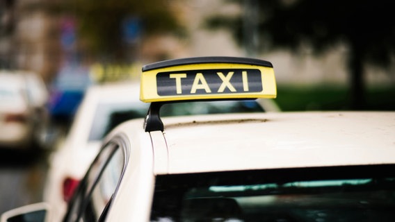 Mehrere Taxen stehen in einer Reihe, Taxi Schild im Fokus. © NDR Foto: Julius Matuschik
