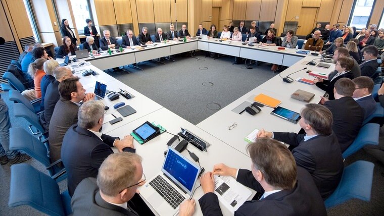 Zahlreiche Politikerinnen und Politiker sitzen in einem großen Viereck im Innenausschuss im Landtag. © dpa - Bildfunk Foto: Julian Stratenschulte