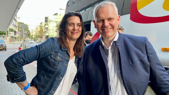 Björn Thümler und Melanie Brinkmann, Virologin am Helmholtz-Zentrum für Infektionsforschung stehen vor einem Bus in Israel. © Niedersächsisches Ministerium für Wissenschaft und Kultur 