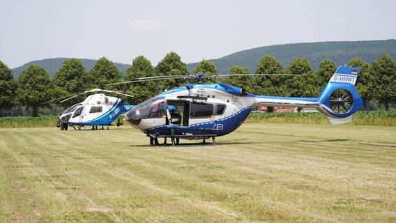 Zwei Hubschrauber der Polizei stehen auf einem Feld. © Leon Stock/NEWS5/dpa Foto: Leon Stock