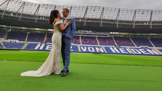 Eine Ehepaar steht nach der Trauung im Stadion von Hannover 96. Eine Ehepaar steht nach der Trauung im Stadion von Hannover 96. © NDR Foto: Svenja Estner