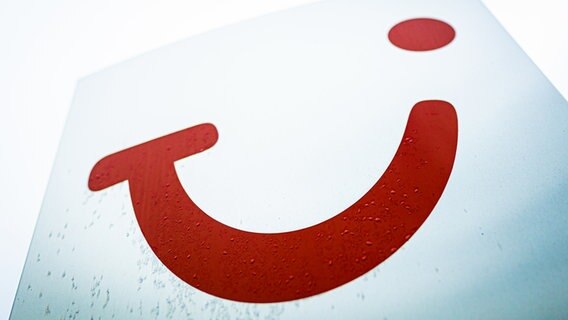 Ein Logo der Tui AG ist vor einem Gebäude der Konzernzentrale auf einem Schild zu sehen. © dpa Foto: Moritz Frankenberg