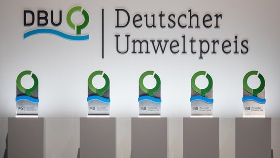 Die Pokale für die Preisträger des Umweltpreises der Deutschen Bundesstiftung Umwelt (DBU) stehen auf der Bühne. © picture alliance/dpa Foto: Michael Reichel