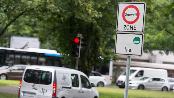 Ein Auto steht in Hannover an einer Ampel hinter einem Schild mit der Aufschrift "Umweltzone". © picture alliance/dpa Foto: Sebastian Gollnow
