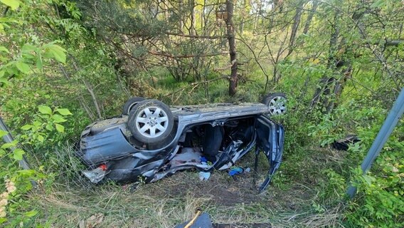 Ein völlig zerstörtes Auto liegt auf dem Kopf neben der A2. © dpa-Bildfunk Foto: TNN/dpa