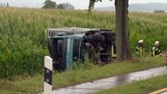 Ein Schweinelaster liegt nach einem Unfall auf der Seite in einem Straßengraben. © HannoverReporter 