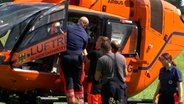 Ein Rettungshubschrauber macht sich fertig zum Start von einer Wiese an der Aller. © HannoverReporter 