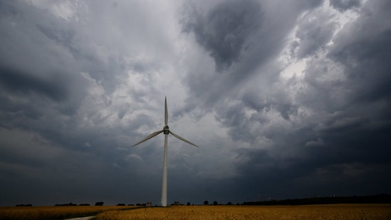 Dunkle Wolken ziehen in der Region Hannover am Himmel. Im Vordergrund eine Windkraftanlage. © Julian Stratenschulte/dpa Foto: Julian Stratenschulte/dpa