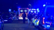 Einsatzkräfte des Rettungsdienstes und der Polizei stehen in einer Straße, nachdem eine junge Frau mit einem Messer getötet wurde. © TeleNewsNetwork 