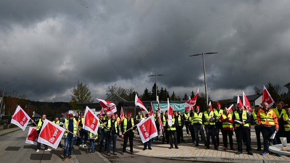 Mitarbeiter der Südwestdeutschen Landesverkehrs GmbH (SWEG) stehen bei einer Kundgebung im Rahmen eines Warnstreiks auf vor dem Bahnhof in Gammertingen. © dpa-Bildfunk Foto: Bernd Weißbrod/dpa