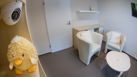 Ein Regal mit einer kleinen Videokamera steht in einem Verhörzimmer für Kinder und Jugendliche im Landgericht in Hildesheim. © dpa Foto: Julian Stratenschulte