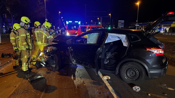 Feuerwehrleute an einem Unfallauto auf einer Straße in Hannover-Vinnhorst. © Feuerwehr Hannover 